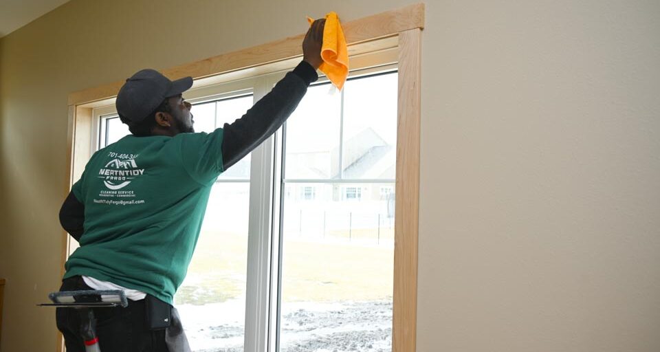 Man from cleaning service cleaning windows of a new home